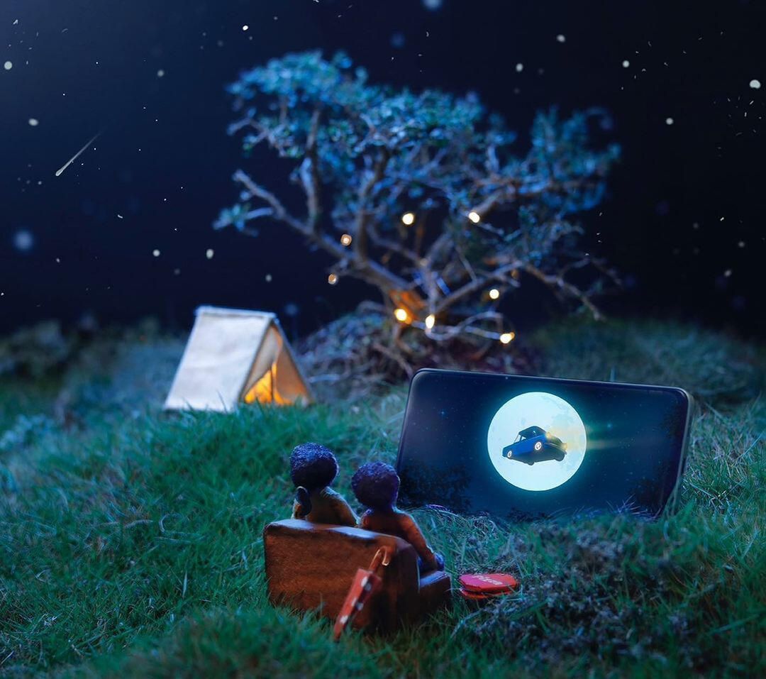 Night scene with a tent, a glowing tree and the phone