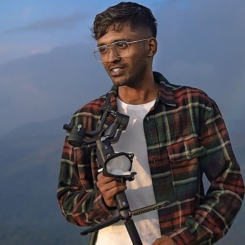 Sooraj holding a gimbal on a hilltop at dusk